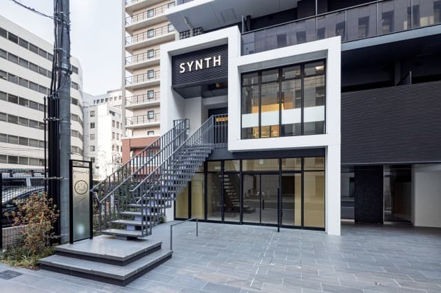 外観_エントランス。モノクロでスタイリッシュな入り口です。SYNTHのロゴが目印になります。