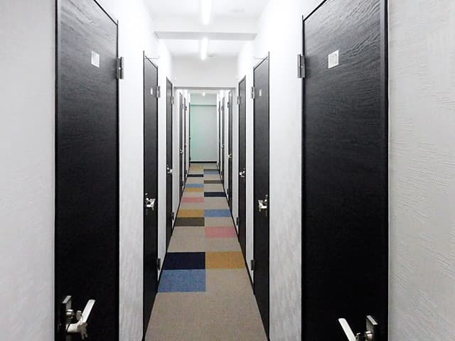 内観_白い壁と、黒い扉でモノトーンでおしゃれな壁際です。各個室鍵付きなのでセキュリティも安心です。