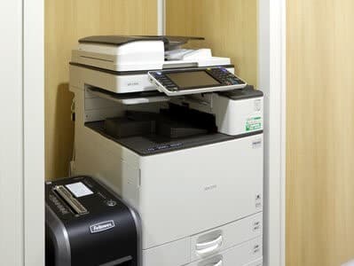 共用部_複合機。オフィス内にあるプリンターはモノクロ1面11円/カラー1面44円でご利用いただけます。