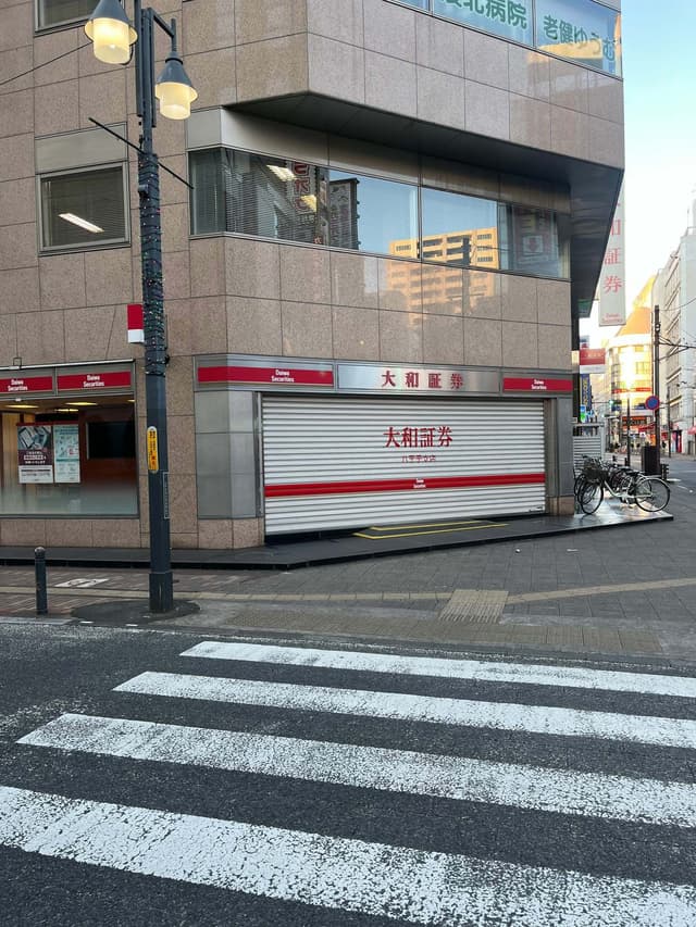 近隣建物_大和証券のビルの道路挟んだ北側に店舗がございます。