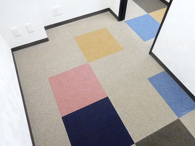 個室_床にはカラフルでおしゃれなカーペットが敷いてあります。