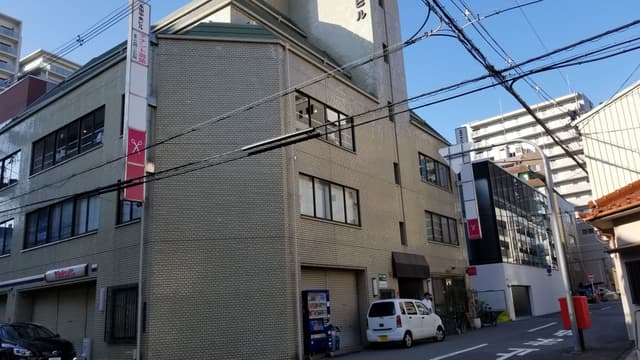 外観_クリーム色のタイルの貼られたオフィスビルです