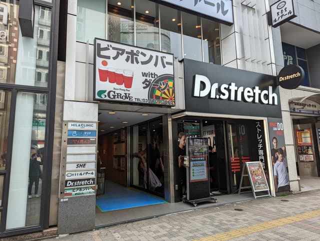外観_ビル入り口。ストレッチ専門店の看板が目印です。オフィスのあるビルには飲食店やクリニックなどもあります。
