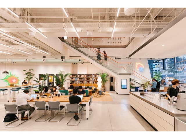 1階ラウンジ(ホットデスクエリア)。個室をご契約の方も、フリーデスク会員の方もご利用いただけます。※写真はイメージです。© WeWork