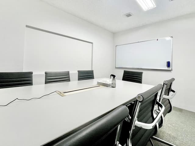 共用部_会議室。最大7名入れる会議室は、ホワイトボードとモニターを完備。広々とした長机も魅力です。